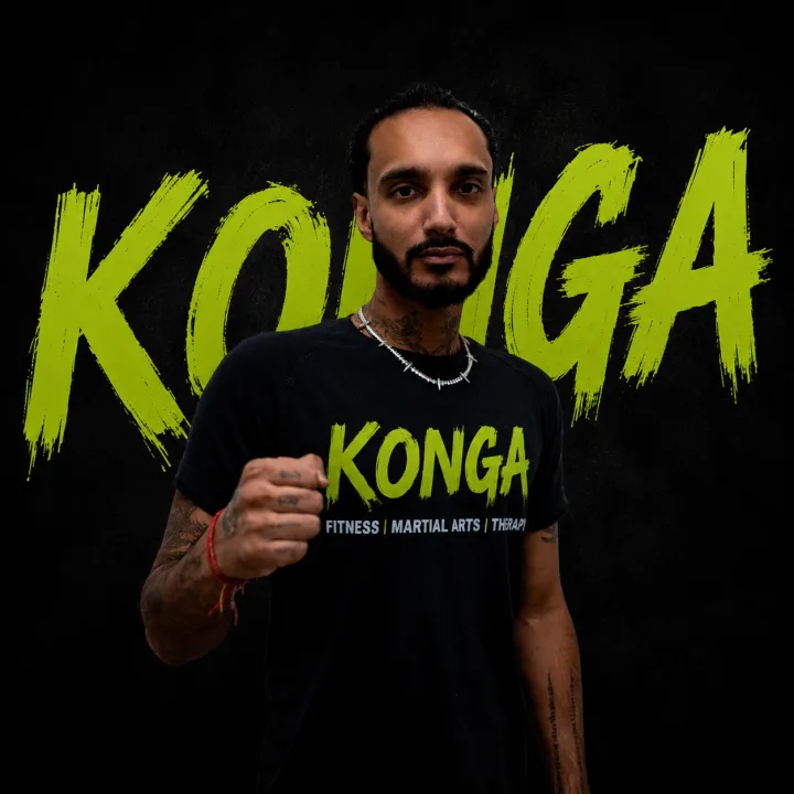 Coach Kevin holding a boxing stance in front of the Konga logo