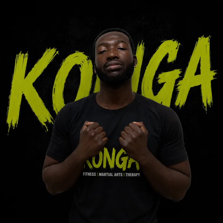 Coach Mike holding his fists up in front of the Konga logo