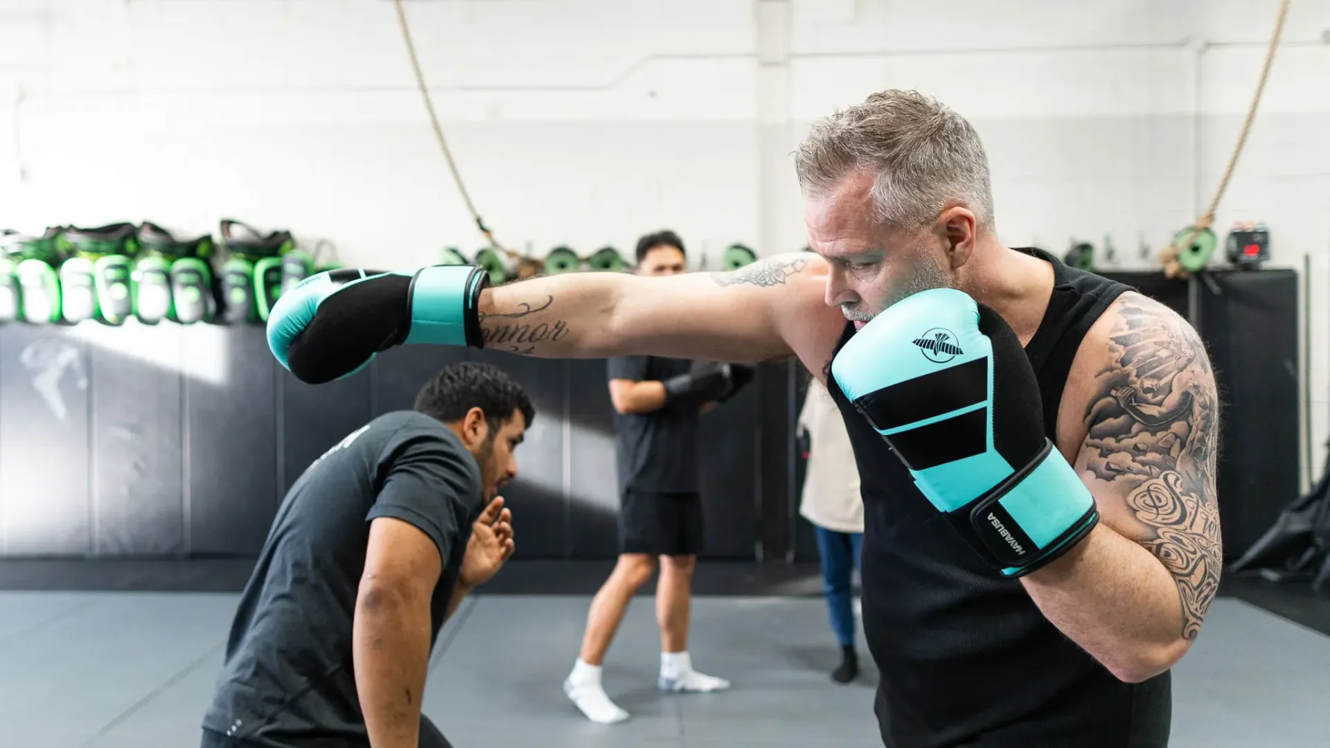 Boxing student extending a punch with a gloved hand