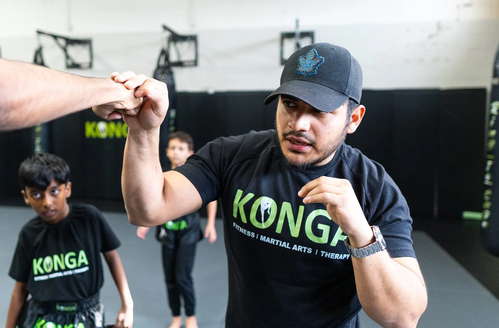 Boxing coach demonstrating hand positioning to a student