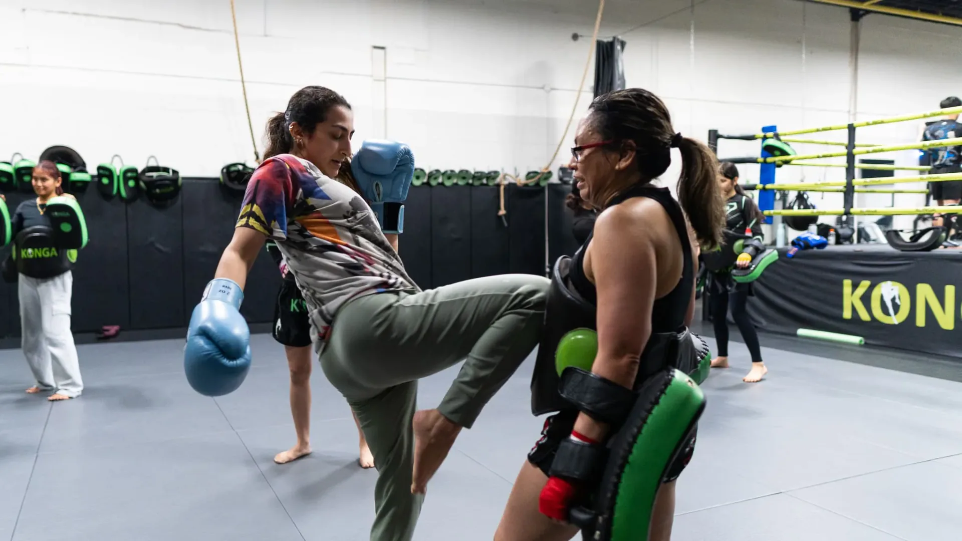 Muay Thai partners practising kicks with protective pads