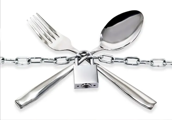Fork and spoon secured together with a chain and padlock