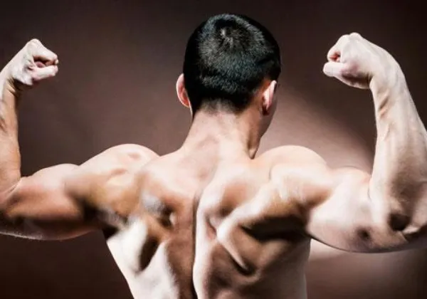 Man flexing both arms with his back to the camera