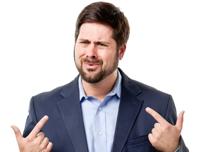 Man in a jacket pointing toward himself