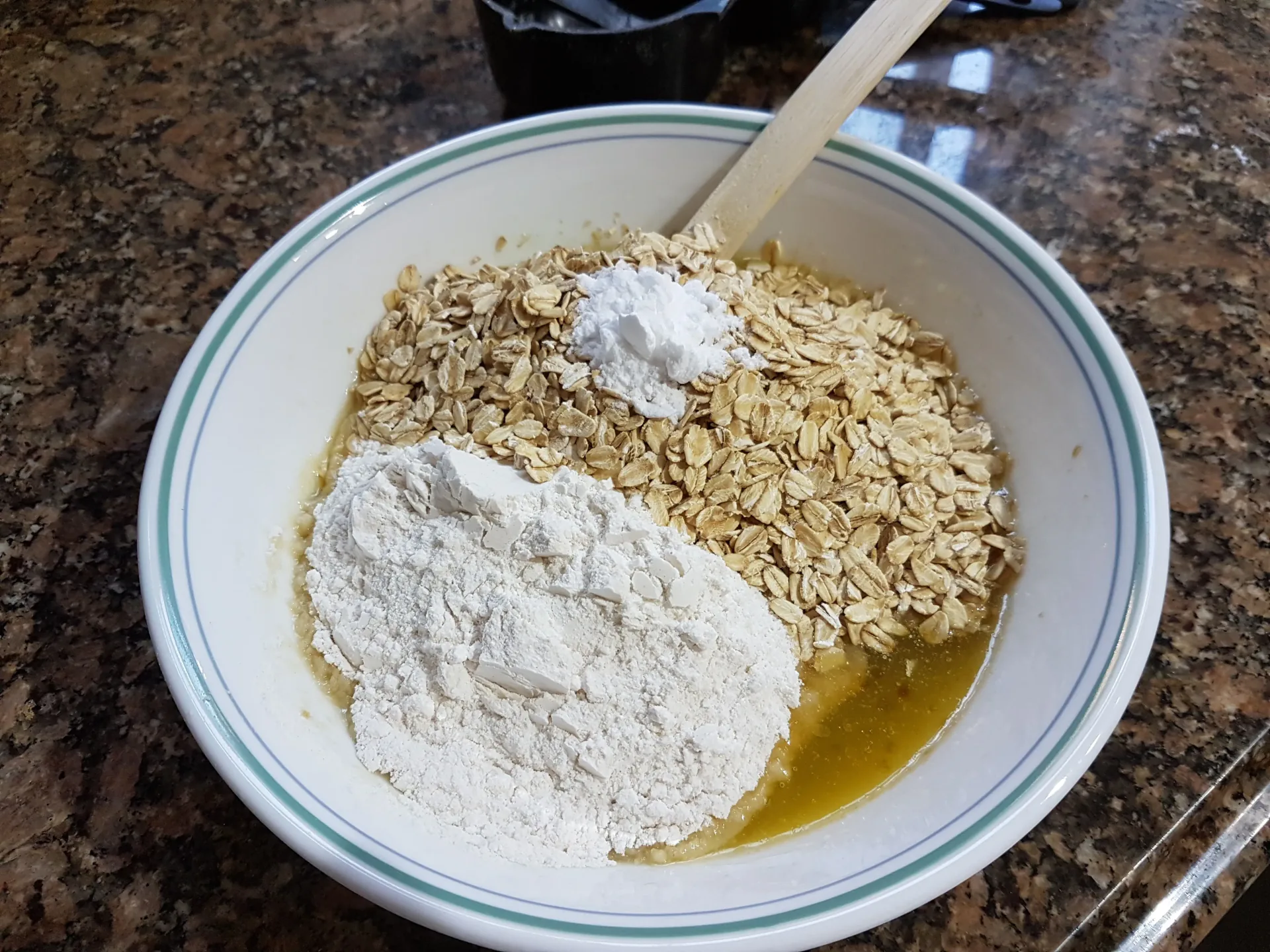 Flour and oats added to melted butter in a mixing bowl
