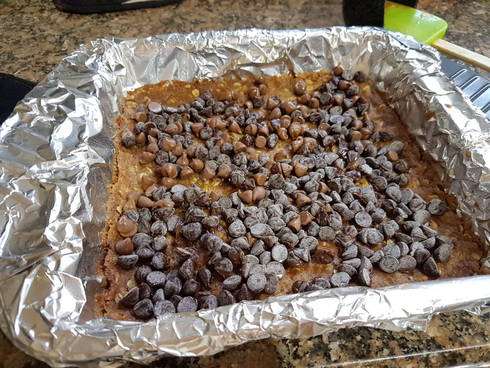 Chocolate chips scattered over the baked oat base