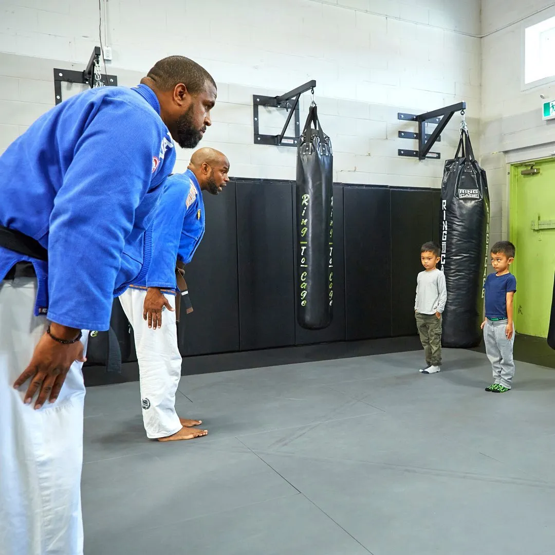 Coach demonstrating a stance to children in a martial arts class