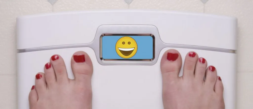 Feet on a bathroom scale displaying a smiley face