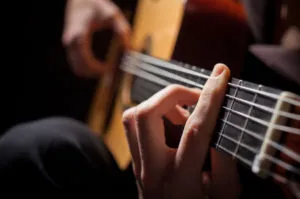 Close-up of a hand pressing guitar strings