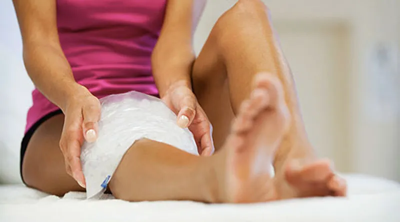Person holding an ice pack against a knee
