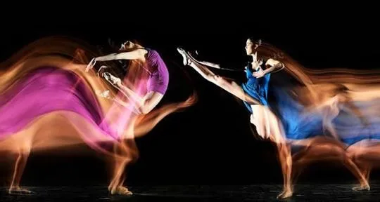 Long-exposure photograph showing people moving and jumping