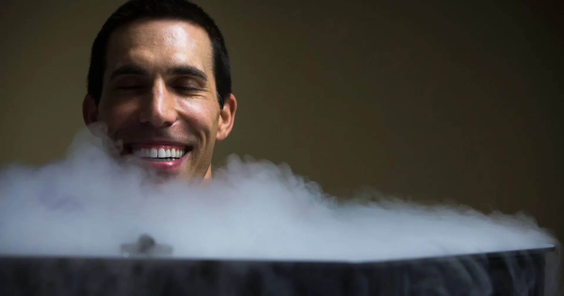 Person in a cryotherapy chamber surrounded by cold mist