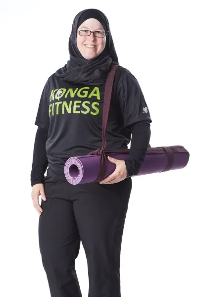 Rebecca Zaidi holding a rolled exercise mat