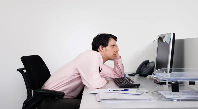 Office worker leaning forward with his head resting on one hand