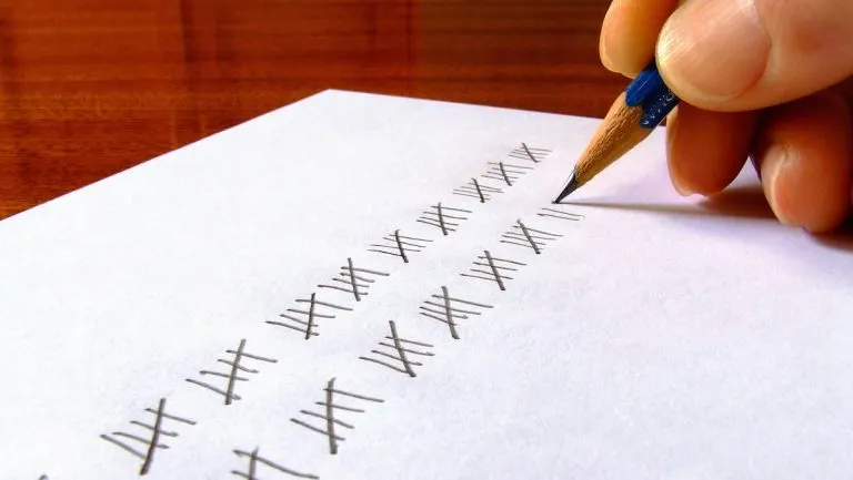 Hand recording tally marks on paper