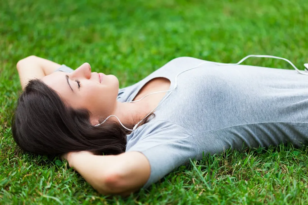 Woman resting on grass with headphones