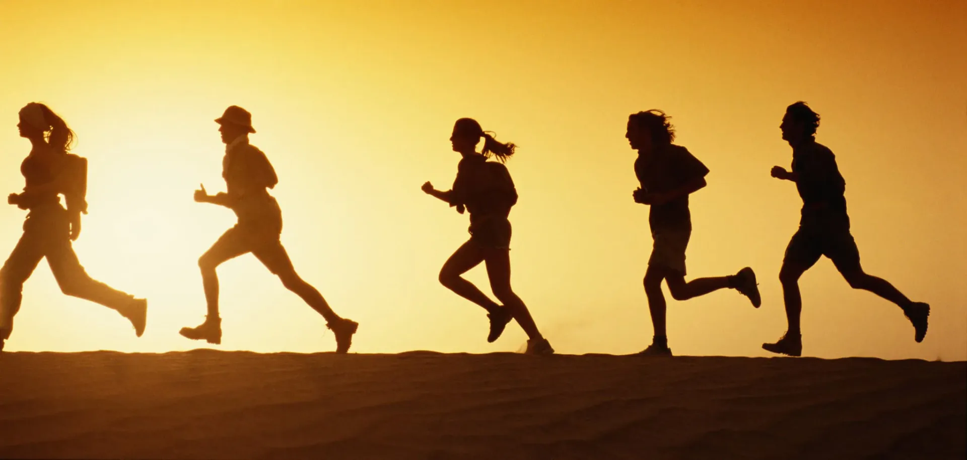 Silhouettes of runners at sunset