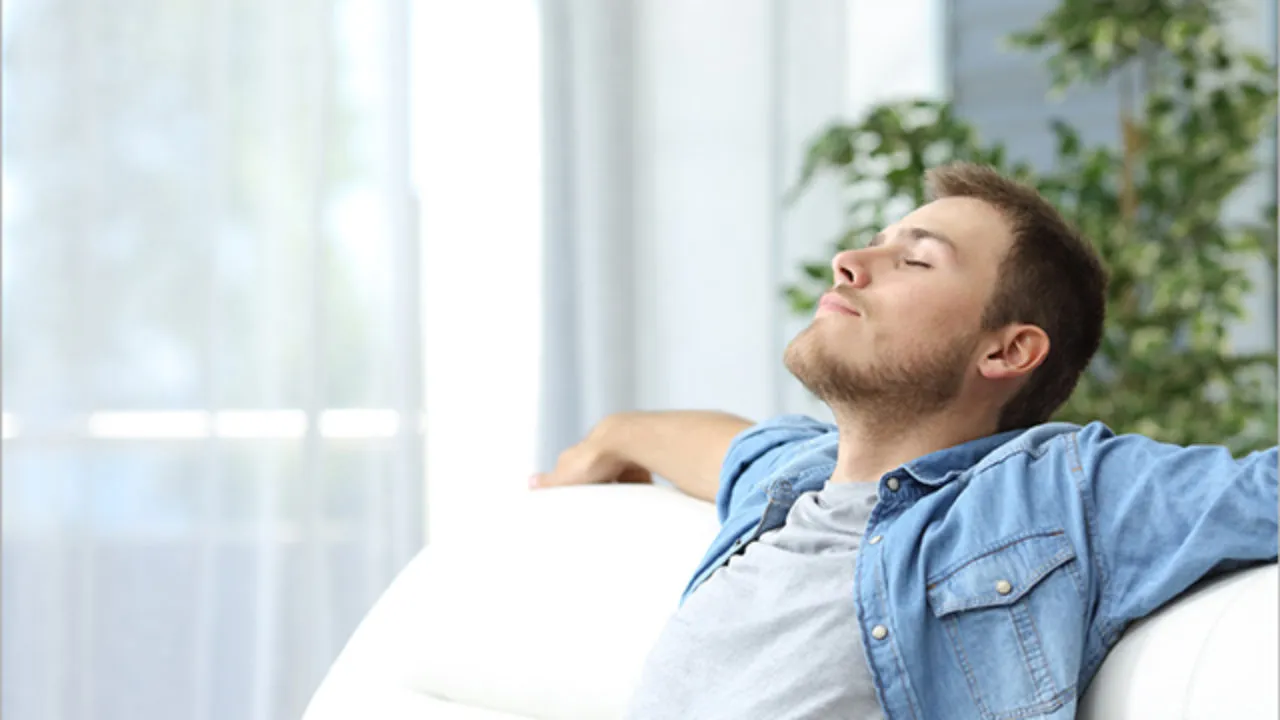 Man leaning back with eyes closed and arms relaxed