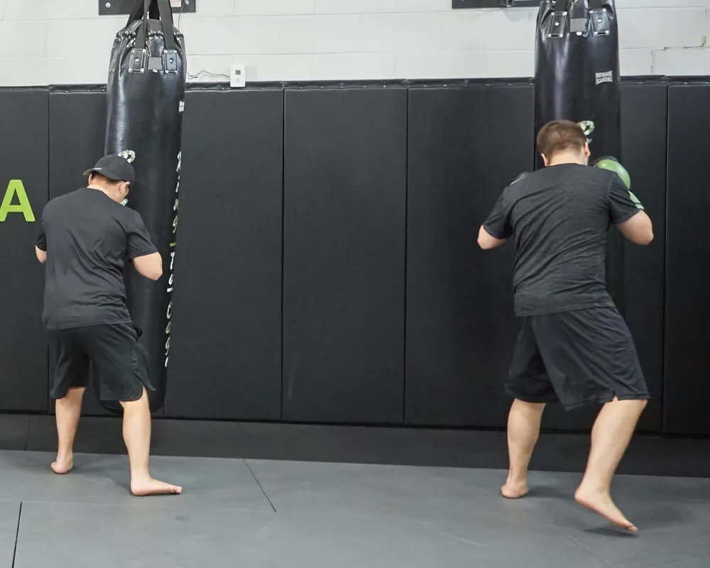 Two members training on punching bags