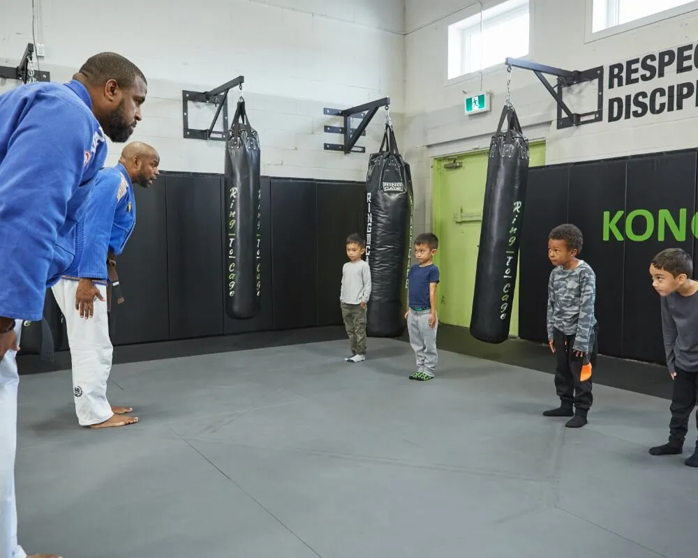 Coach demonstrating a martial arts stance to children