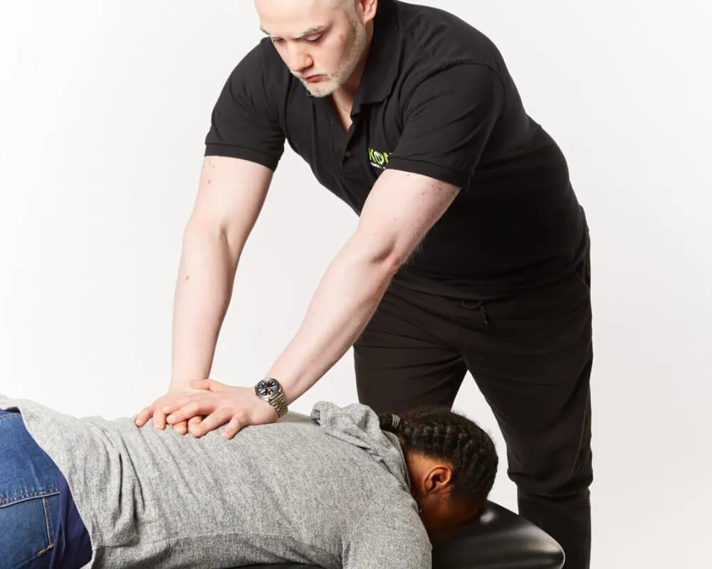 Practitioner treating a client's back on a treatment table
