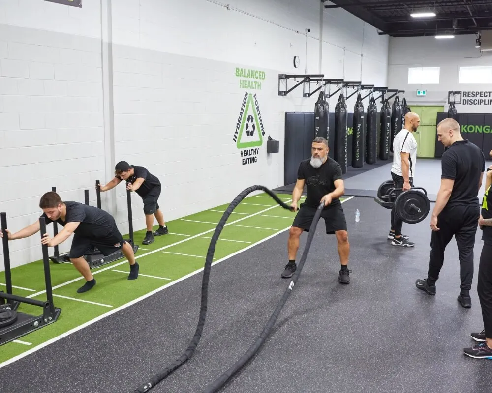 Members training with battle ropes, weights and sleds at Konga Fitness