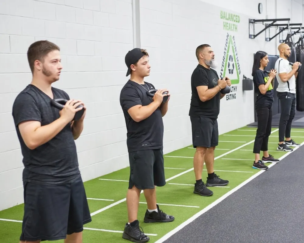 Members holding weights during a group strength class