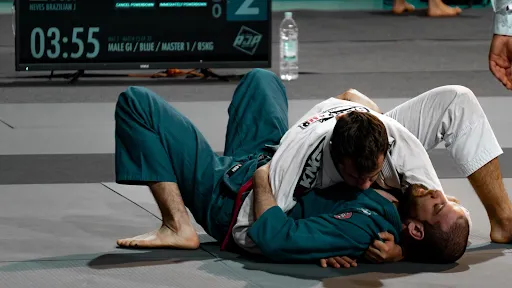 Two martial arts students grappling on the mats