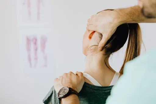 Practitioner supporting a client's head and shoulder during treatment