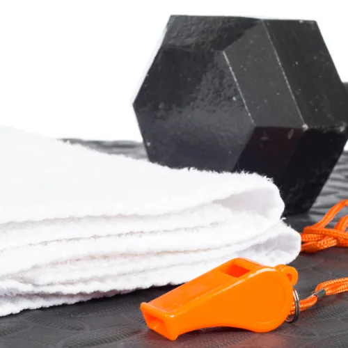 Dumbbell, folded towel and orange whistle