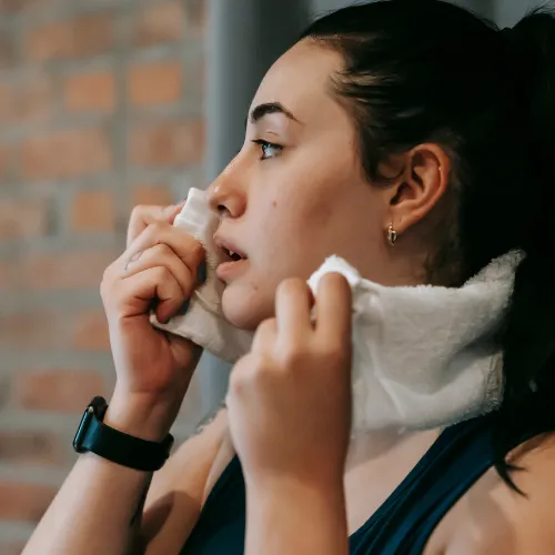 Woman with a towel around her neck after a workout