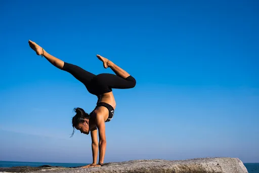Woman balancing upside down on her hands outdoors
