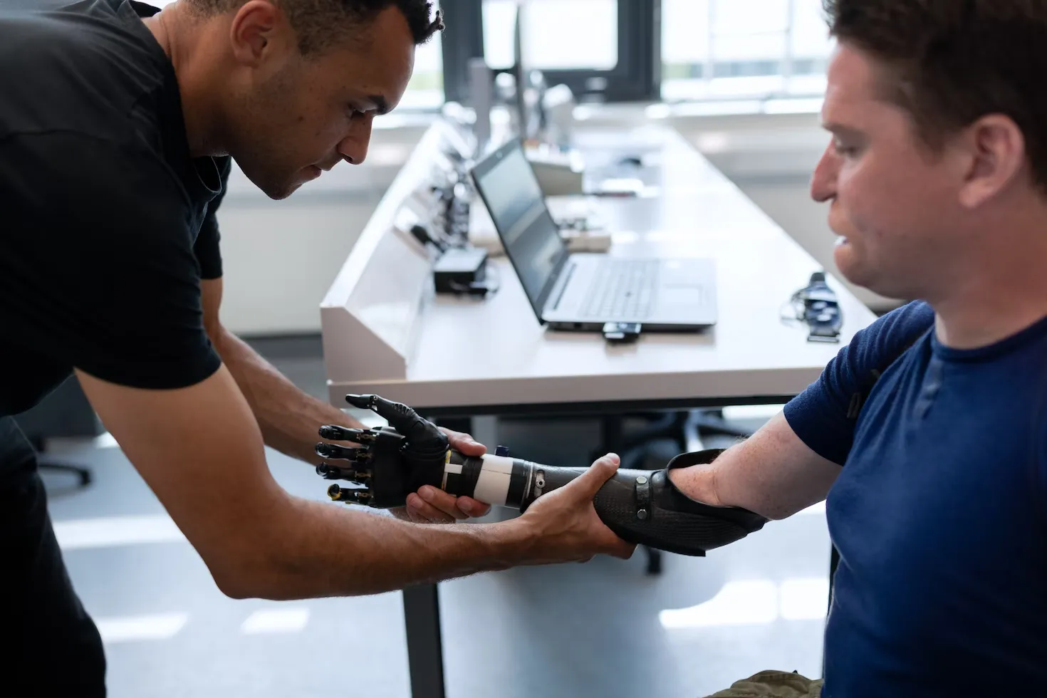 Practitioner helping a client use a hand and wrist exercise device