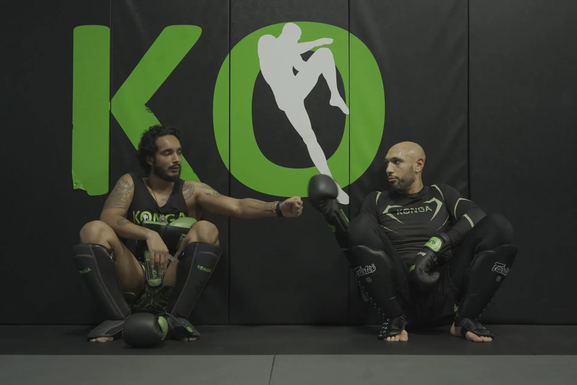 Members resting together beside the Konga wall logo