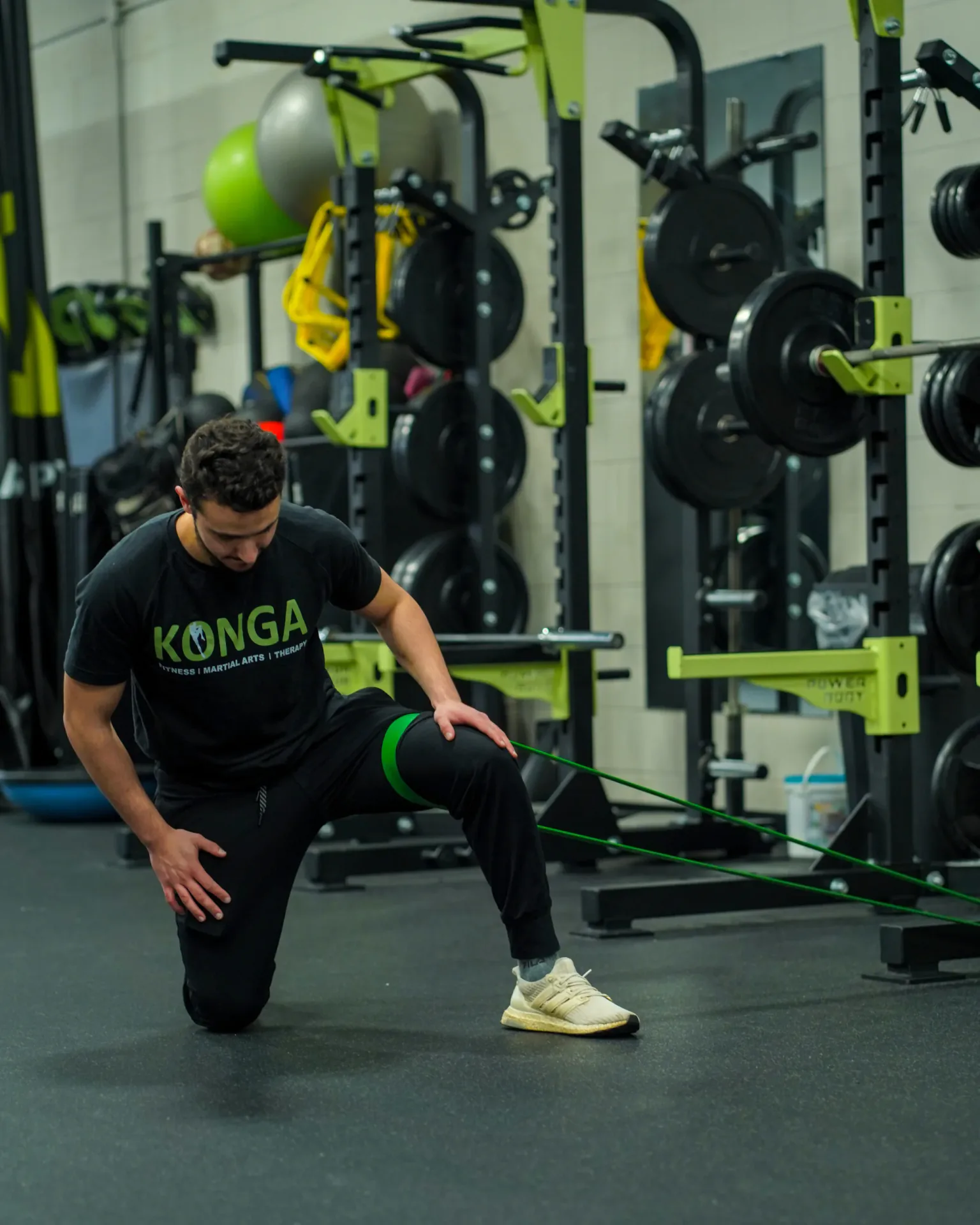 Member performing a lunge beside the weight-training equipment