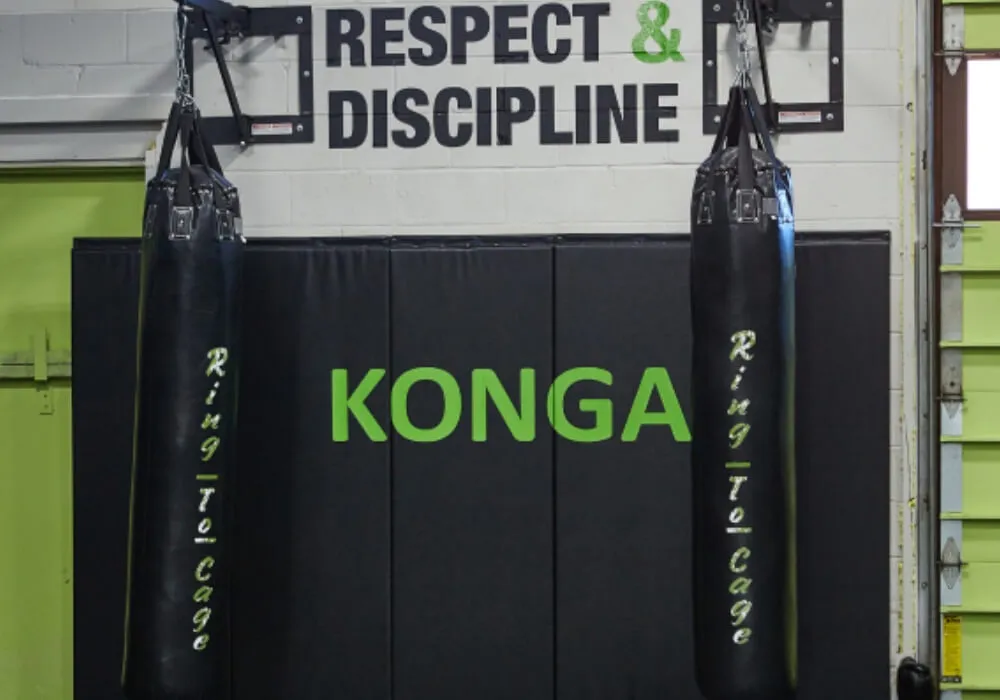 Punching bags beneath the Respect and Discipline sign at Konga Fitness