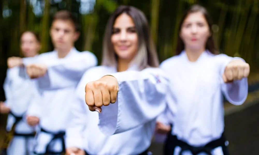 Children in martial arts uniforms practising straight punches