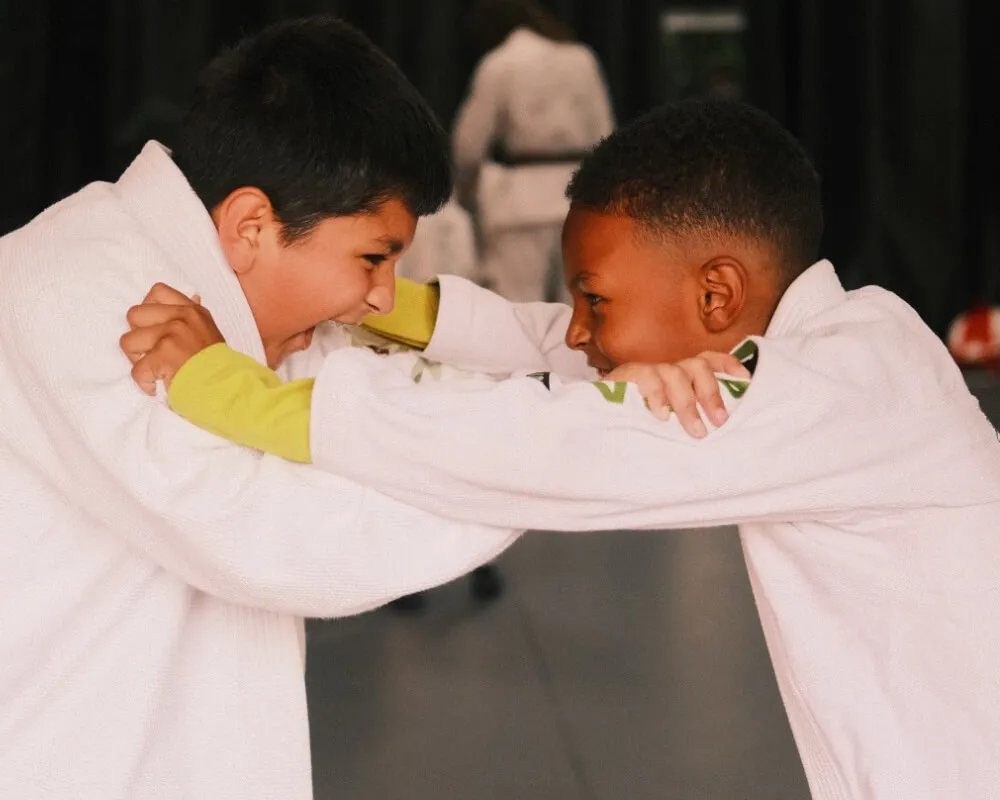 Two children practising grips in Brazilian Jiu-Jitsu uniforms