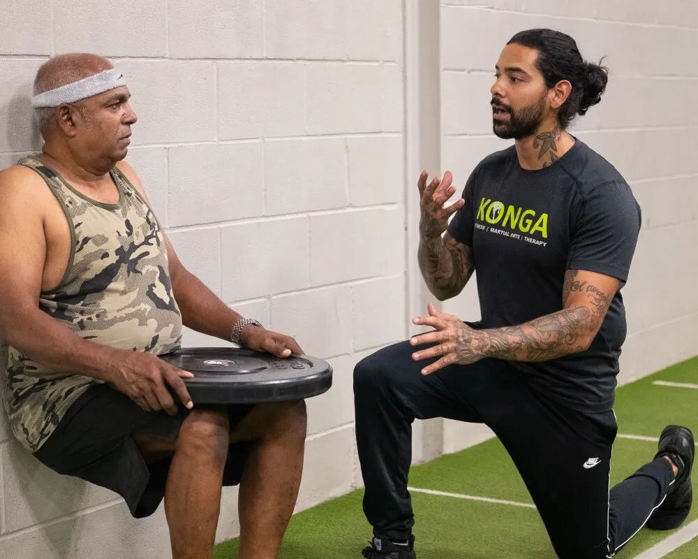 Trainer discussing an exercise with a seated member
