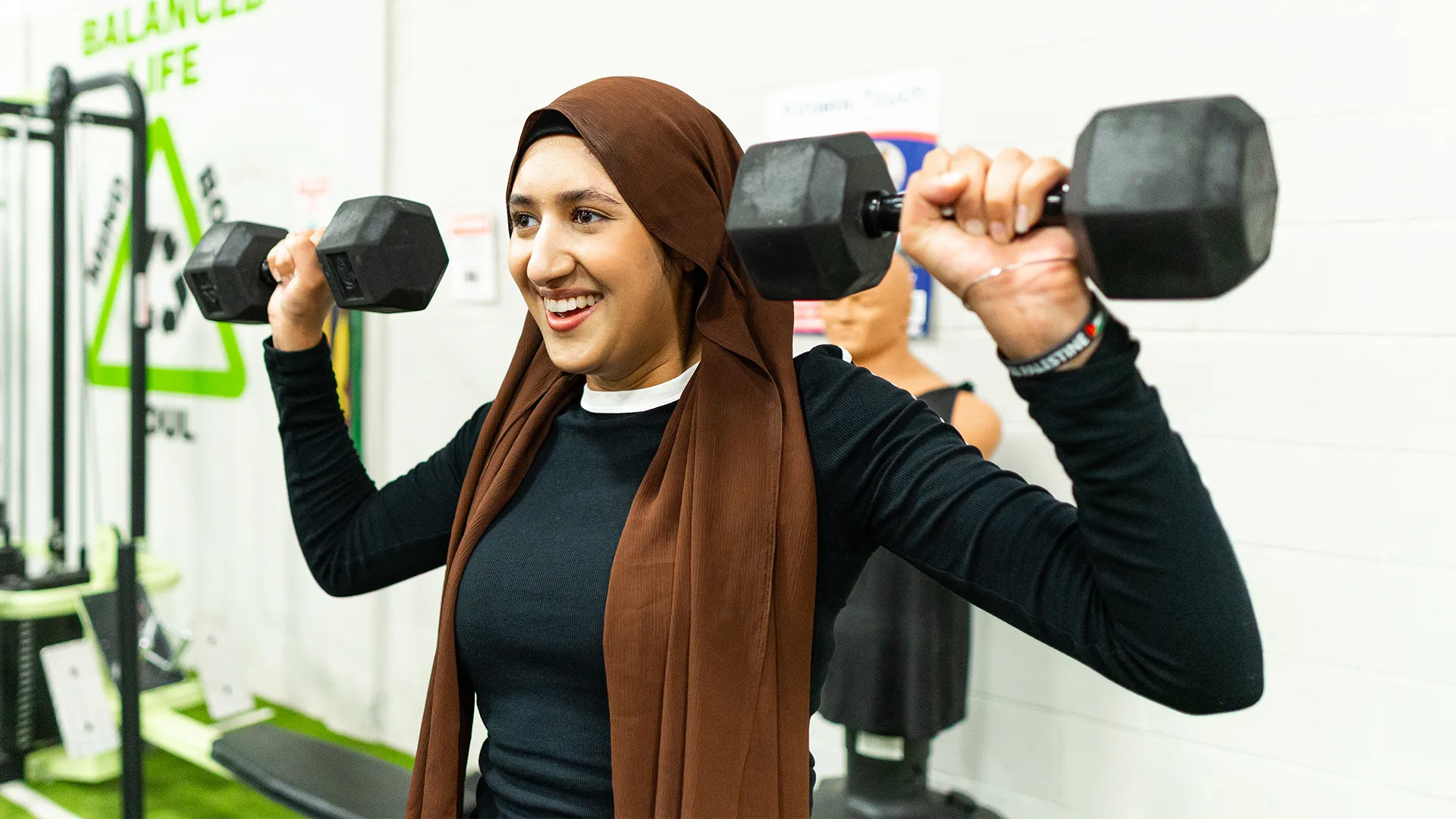 Woman lifting dumbbells at shoulder height